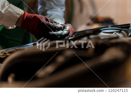 Close-Up of Mechanic's Hands Working on an Engine Component 120247115