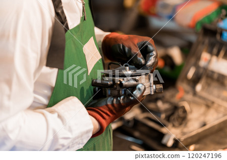 Mechanic Inspecting Automotive Repair Component with Careful Attention 120247196