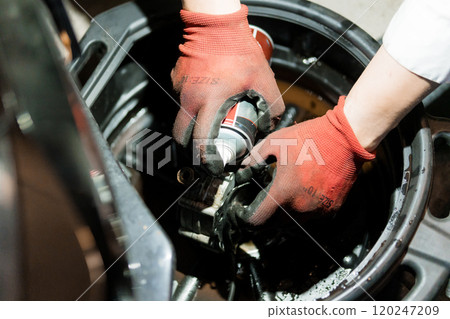 Oil Change Process with Hands Wearing Red Gloves in a Workshop Oil Change Process with Hands Wearing Red Gloves in a Workshop 120247209
