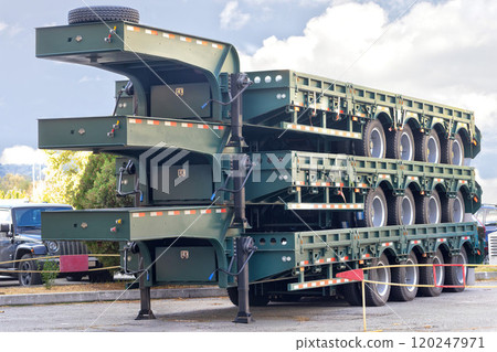 Innovative stacked transport trailers on display in a vibrant outdoor setting. Innovative stacked transport trailers on display in a vibrant outdoor setting. 120247971