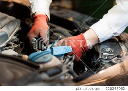 Hands of a Mechanic Working on a Car Engine Hands of a Mechanic Working on a Car Engine 120248062