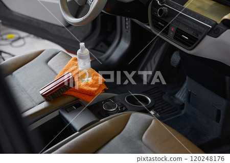 Cleansing brush, towel and detergent on front passenger car seat 120248176