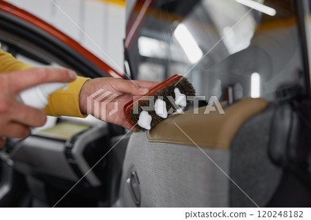 Male master applying foam on brush for car detailing in wash service 120248182