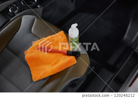 Cleansing brush, towel and detergent on front passenger car seat 120248212