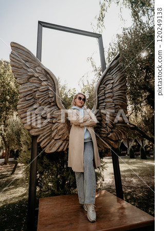 Woman Posing with Angel Wings Sculpture 120249138