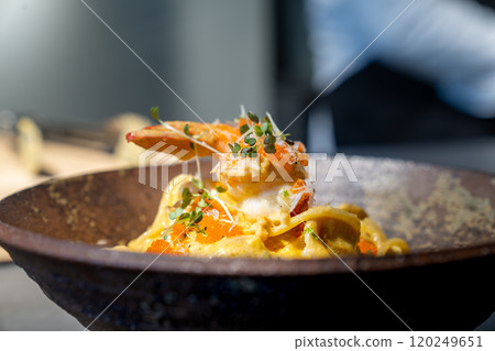 Spaghetti Carbonara pasta Egg and Cheese creamy cream sauce with Shrimp and micro herb decoration on the top of it of earthware circle bowl in studio light. Spaghetti Carbonara pasta Egg and Cheese creamy cream sauce with Shrimp and micro herb decoration on the top of it of earthware circle bowl in studio light. 120249651