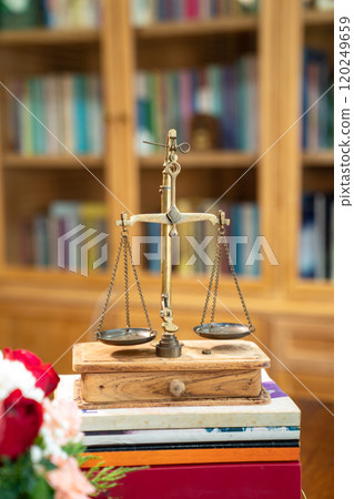 Classic Golden Scale in vintage mood and tone lays on book pile or tower. Classic Golden Scale in vintage mood and tone lays on book pile or tower. 120249659