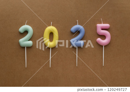Numbers 2025 made from Colored candles on brown background. Holiday background Happy New Year 2025. Celebrating New Year 120249727