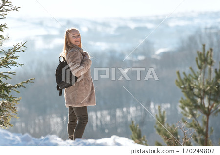 Beautiful young woman in fur coat walking in snowy forest on winter day Beautiful young woman in fur coat walking in snowy forest on winter day 120249802