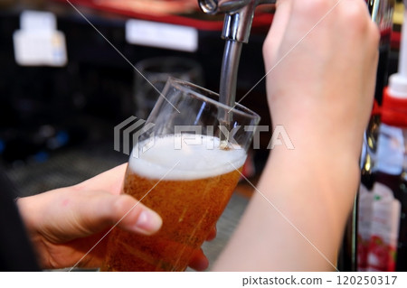 Pouring a Fresh and Refreshing Glass of Beer at the Bustling Bar with Friends Present Pouring a Fresh and Refreshing Glass of Beer at the Bustling Bar with Friends Present 120250317