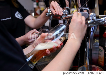 A Bartender Skillfully Pouring Fresh Beer at a Bustling and Lively Bar Scene Filled with Friends A Bartender Skillfully Pouring Fresh Beer at a Bustling and Lively Bar Scene Filled with Friends 120250329