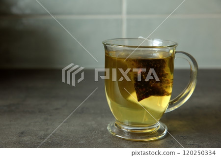Aromatic and Invigorating Tea in a Clear Glass Mug with Infusion of Natural Leaves 120250334