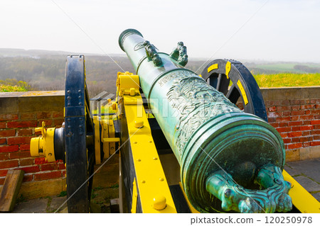 The cannon at Konigstein Fortress stands proudly, showcasing intricate details and historic significance. This location offers stunning views over the surrounding landscape and rich history. 120250978