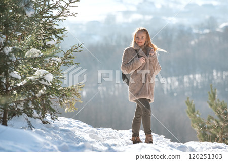 Young woman in winter forest. Beautiful girl on the background of winter landscape. 120251303