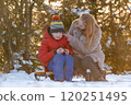 Young woman with son in winter forest on picnic drink hot tea in warm light. Happy family spends weekends outside the city. 120251495