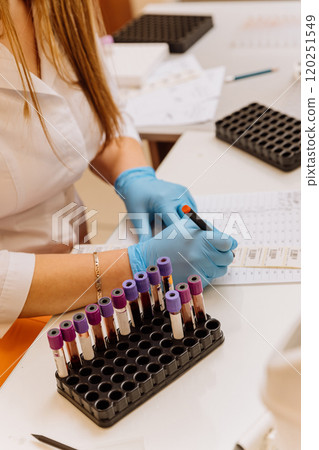 Laboratory worker documenting blood samples during medical testing in a clinical lab environment Laboratory worker documenting blood samples during medical testing in a clinical lab environment 120251549