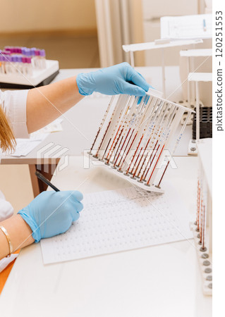 Laboratory technician analyzing blood samples for diagnostics in a clinical laboratory 120251553