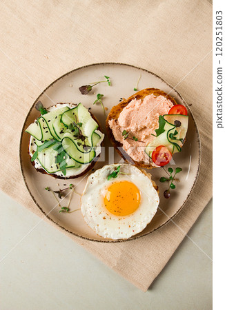 Assortment of sandwiches, white bread, fried egg, cream cheese and cucumber, capelin caviar, sesame bun, breakfast, on a white table, no people, Assortment of sandwiches, white bread, fried egg, cream cheese and cucumber, capelin caviar, sesame bun, breakfast, on a white table, no people, 120251803
