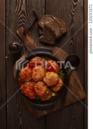Beef meat balls in tomato sauce, with spices and herbs, on a wooden background, top view, no people, Beef meat balls in tomato sauce, with spices and herbs, on a wooden background, top view, no people, 120251871