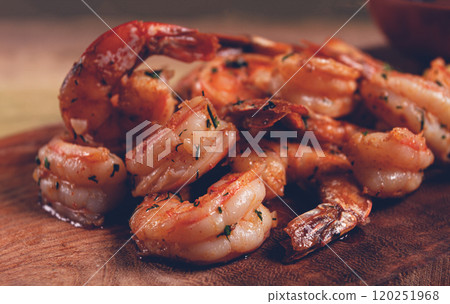 fried tiger prawns, jumbo, in garlic sauce, in butter, with herbs, on a wooden board, homemade, no people, 120251968