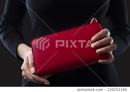 Red leather wallet in female hands 120252160