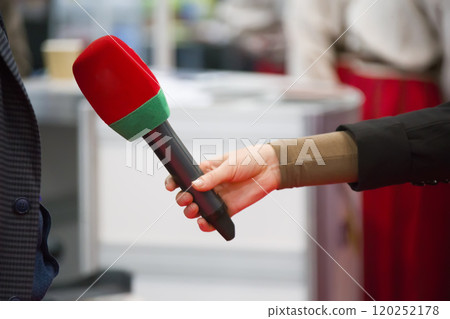 A hand is holding a microphone. Interview A hand is holding a microphone. Interview 120252178