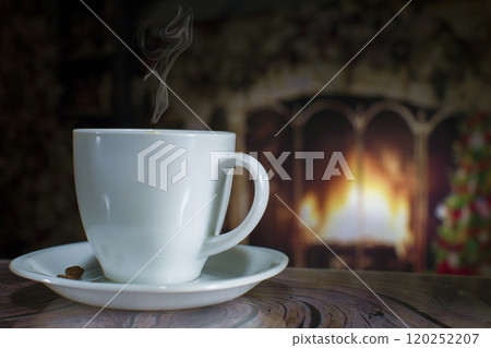 Cup of coffee with smoke on the background of the Christmas fireplace and Christmas tree 120252207
