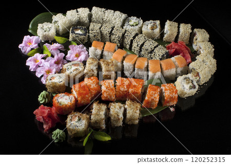 Seth sushi on a black background.Menu of the Japanese restaurant. Several sushi close-ups are beautifully laid out. Traditional Asian food Seth sushi on a black background.Menu of the Japanese restaurant. Several sushi close-ups are beautifully laid out. Traditional Asian food 120252315
