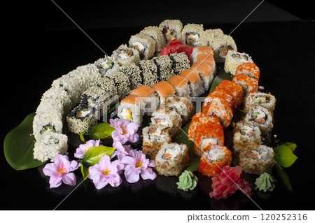 Seth sushi on a black background.Menu of the Japanese restaurant. Several sushi close-ups are beautifully laid out. Traditional Asian food Seth sushi on a black background.Menu of the Japanese restaurant. Several sushi close-ups are beautifully laid out. Traditional Asian food 120252316