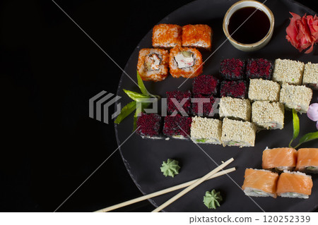Menu of the Japanese restaurant. Several sushi lined on a plate with bamboo sticks and soy sauce Menu of the Japanese restaurant. Several sushi lined on a plate with bamboo sticks and soy sauce 120252339