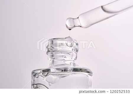 Close-up of a cosmetic bottle with a pipette showing the texture of the serum. Close-up of a cosmetic bottle with a pipette showing the texture of the serum. 120252533