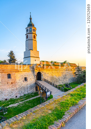 The Clock Tower stands proudly at Kalemegdan Fortress in Belgrade as the sun sets, casting warm hues. 120252669