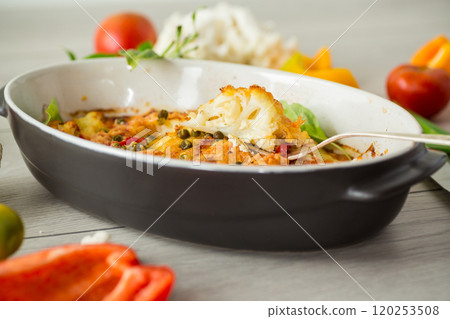 cauliflower baked with sweet pepper and vegetables under cheese 120253508