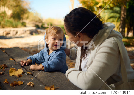 Happy child enjoying outdoor time with family in autumn park Happy child enjoying outdoor time with family in autumn park 120253915