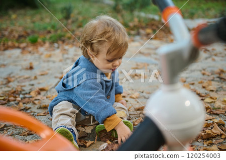 Young child playing on an autumn day in a cozy sweater Young child playing on an autumn day in a cozy sweater 120254003