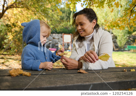 Mother and child bonding with leaves during autumn Mother and child bonding with leaves during autumn 120254126