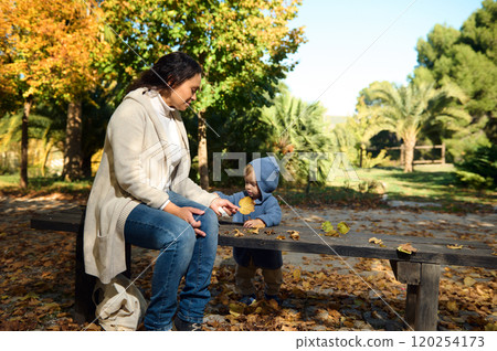 Mother and child enjoying an autumn day in the park Mother and child enjoying an autumn day in the park 120254173