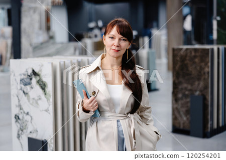 Woman choosing tile samples in a showroom Woman choosing tile samples in a showroom 120254201