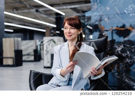 Woman sitting in a chair in a showroom Woman sitting in a chair in a showroom 120254210