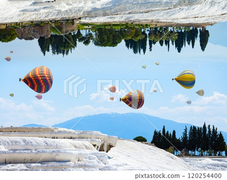 Fantastic unreal world, hot air balloons fly in blue sky between white Pammukale travertines, Turkey 120254400