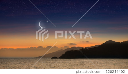 Ramadan background with crescent, stars in glowing sky above mountains and sea. Ramadan background with crescent, stars in glowing sky above mountains and sea. 120254402