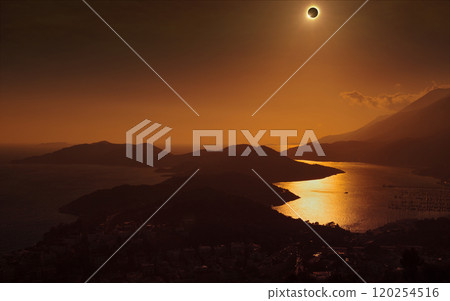Total solar eclipse in dark red sky above mountains and sea 120254516