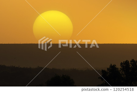 Silhouette of excavator on quarry dump with sunset in background 120254518