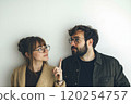 A man and a woman wearing glasses looking at each other. 120254757