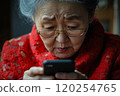 An elderly woman looking at her phone 120254765