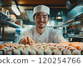 A man in a chef's hat is preparing sushi in a kitchen. 120254766