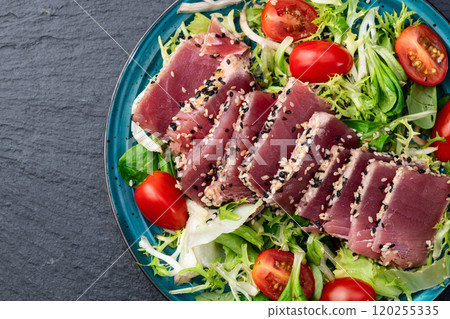 Salad with raw tuna , sesame and cherry tomatoes photography . Top view 120255335