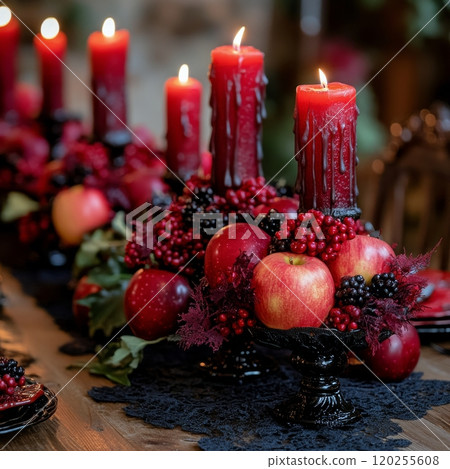 Elegant autumn dinner table setting with apples, red candles, and dark floral arrangements 120255608
