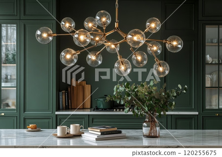 A modern kitchen showcases a beautiful marble countertop with a sophisticated lighting fixture above 120255675