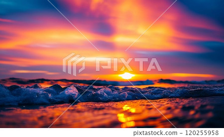 The sun rises over the ocean, casting warm hues across the water. Waves gently roll in, creating bubbles that sparkle in the early light while clouds streak the sky in vibrant colors. Generative AI 120255958